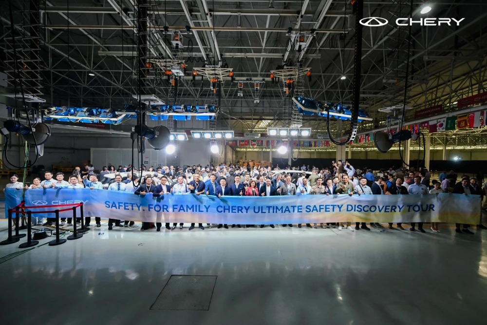 Chery TIGGO9'un başarılı geçen kompozit çarpışma testinin ardından test sahasında kutlama pankartı açan etkinlik katılımcıları ve yetkililer.