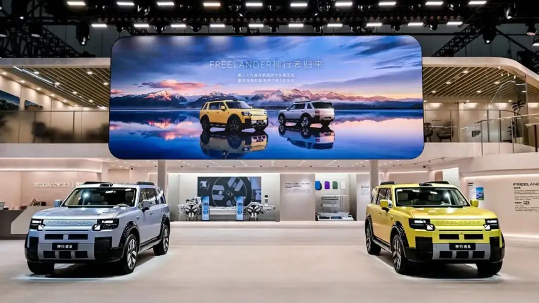 Dev ekran önünde sahnede sergilenen açık mavi ve sarı renkli yeni nesil Chery Freelander modelleri